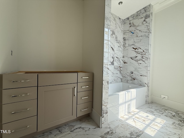 bathroom featuring a bath and marble finish floor