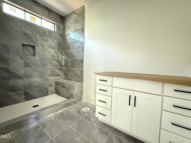 bathroom featuring tiled shower and marble finish floor