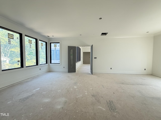 spare room with crown molding and baseboards