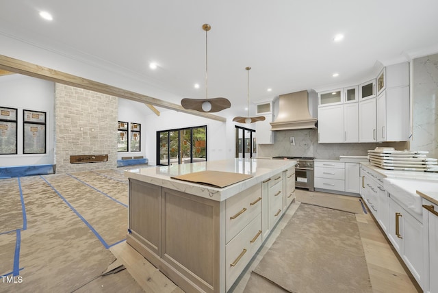 7013 Buckhead Dr, Raleigh, NC 27615 - kitchen featuring custom exhaust hood, high end stove, backsplash, a spacious island, and white cabinets