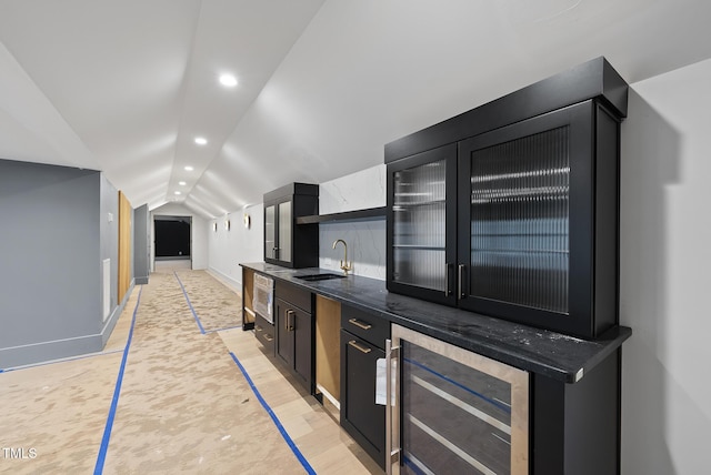 7013 Buckhead Dr, Raleigh, NC 27615 - kitchen featuring wine cooler, dark cabinets, vaulted ceiling, recessed lighting, and glass insert cabinets