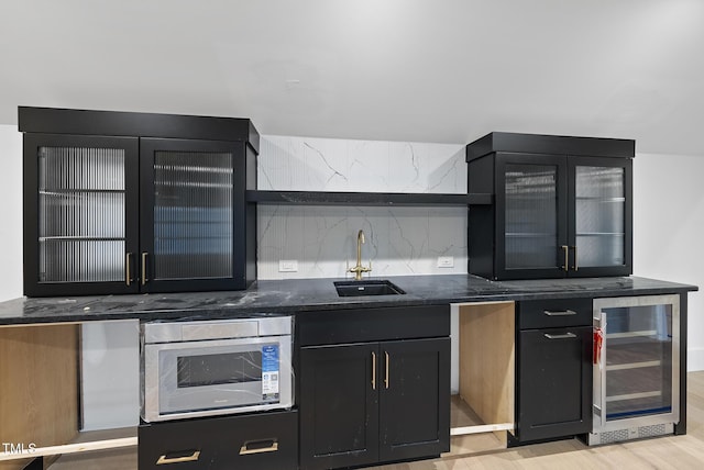 7013 Buckhead Dr, Raleigh, NC 27615 - kitchen with beverage cooler, stainless steel microwave, dark cabinets, and glass insert cabinets