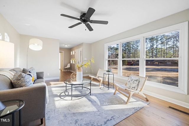 living room featuring ceiling fan and light hardwood / wood-style floors