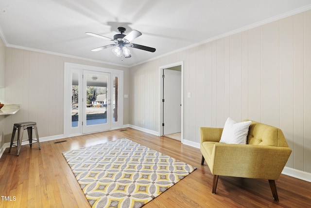 sitting room with ceiling fan, hardwood / wood-style floors, and crown molding