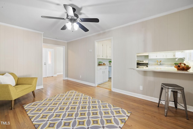 living area featuring light wood-type flooring, ceiling fan, and ornamental molding