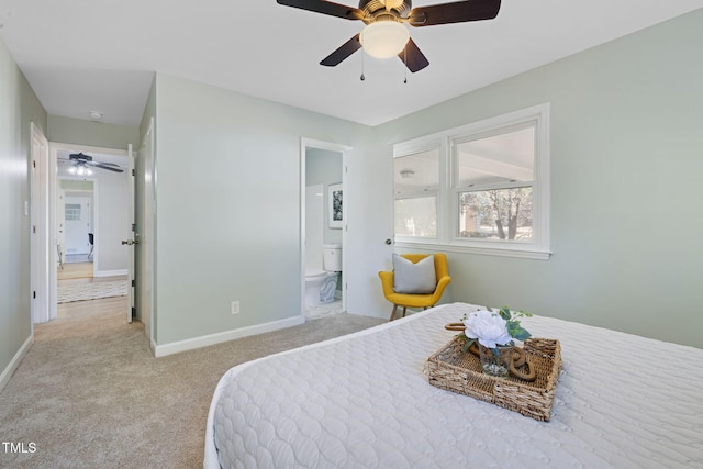 bedroom with ceiling fan, light carpet, and ensuite bath