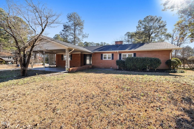 ranch-style home with a front yard and a carport