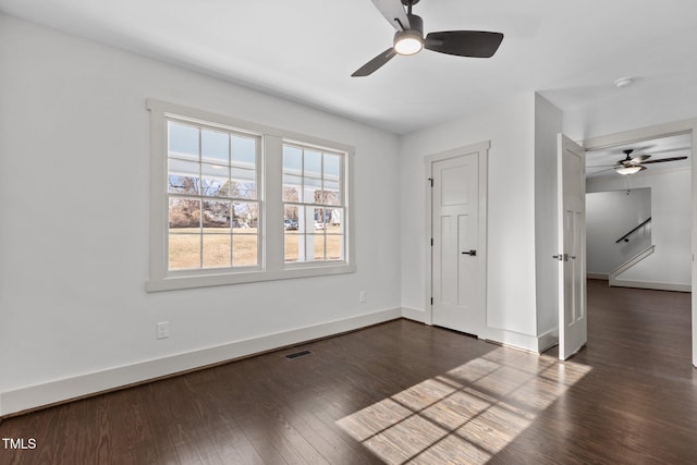 empty room featuring ceiling fan and dark hardwood / wood-style floors