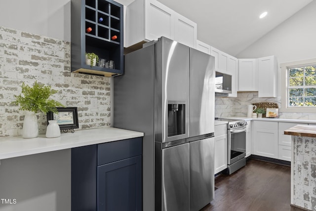 kitchen featuring white cabinetry, stainless steel appliances, decorative backsplash, dark hardwood / wood-style floors, and vaulted ceiling