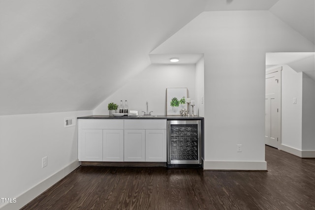 bar with sink, white cabinetry, wine cooler, and lofted ceiling