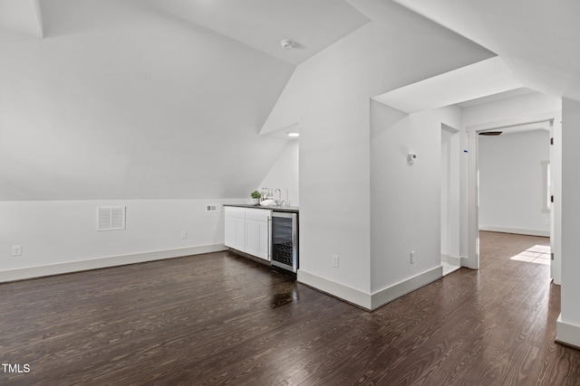 bonus room with sink, wine cooler, dark hardwood / wood-style flooring, and lofted ceiling