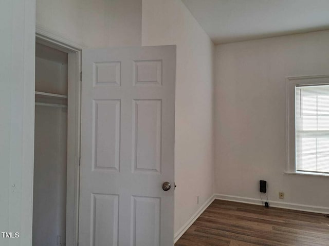 unfurnished bedroom with a closet and dark hardwood / wood-style floors