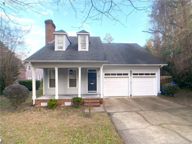 view of front of home with a front yard, covered porch, and a garage