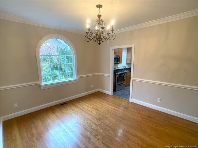 unfurnished dining area with ornamental molding, sink, dark hardwood / wood-style floors, and a notable chandelier