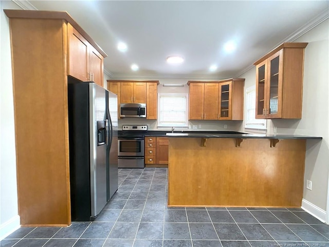 kitchen featuring kitchen peninsula, sink, a kitchen breakfast bar, stainless steel appliances, and ornamental molding