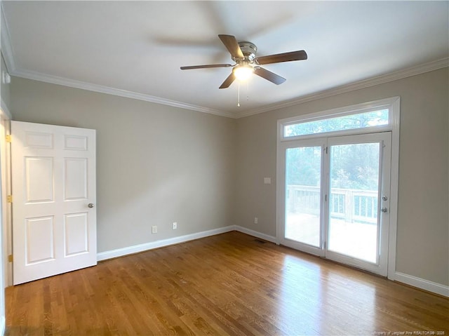 empty room featuring ceiling fan, ornamental molding, and hardwood / wood-style floors