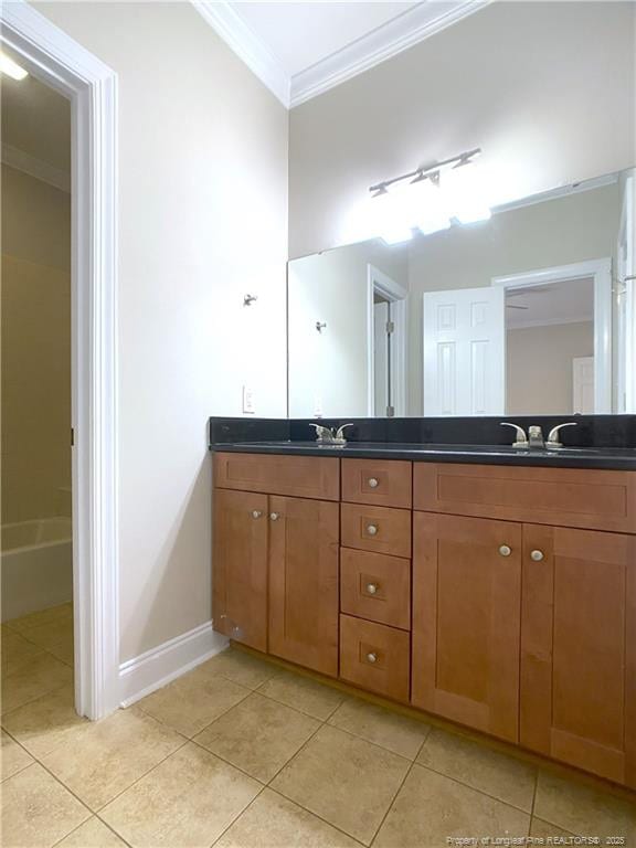 bathroom with tile patterned flooring, crown molding, and vanity