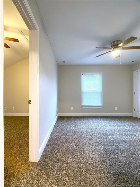 empty room featuring ceiling fan, dark carpet, and lofted ceiling