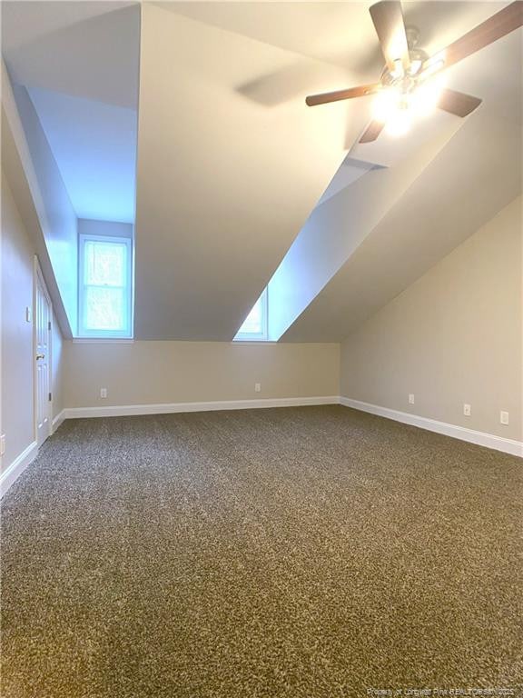 bonus room featuring ceiling fan, lofted ceiling with skylight, and carpet flooring