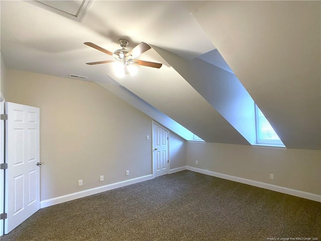 additional living space with dark colored carpet, lofted ceiling, and ceiling fan