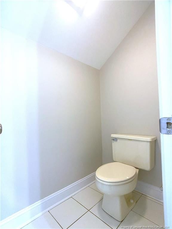 bathroom with tile patterned floors, lofted ceiling, and toilet