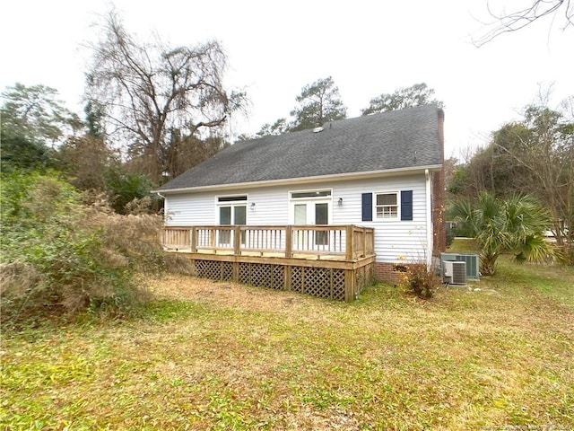 rear view of property with a deck, a yard, and central air condition unit