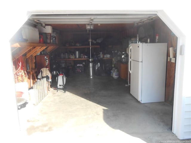 garage with white refrigerator and a garage door opener