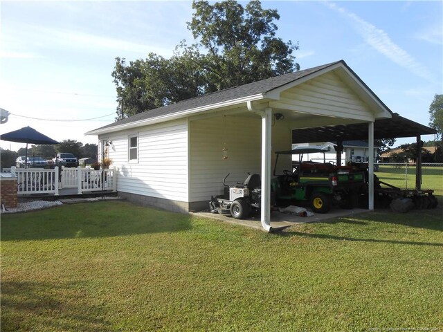 exterior space with a carport and a lawn