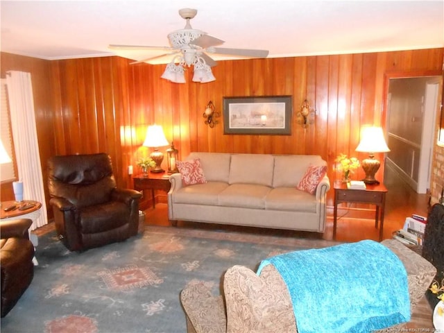 living room with ceiling fan and wood walls