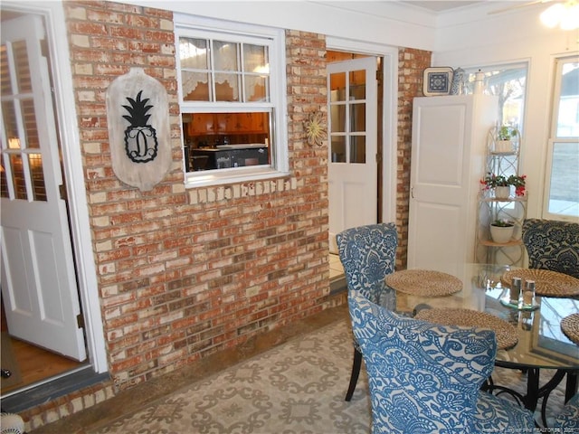 dining room featuring brick wall