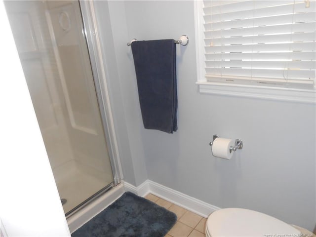 bathroom featuring tile patterned flooring, toilet, and walk in shower