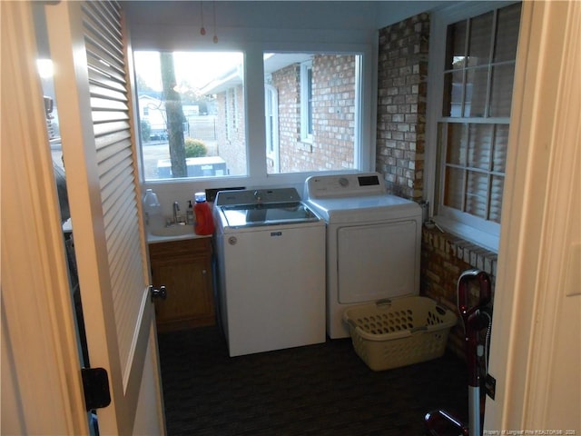 laundry area featuring cabinets, sink, and washer and clothes dryer