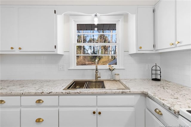 kitchen featuring backsplash, sink, and white cabinets