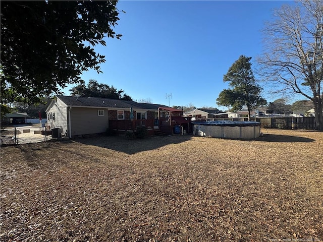 rear view of property featuring a pool side deck