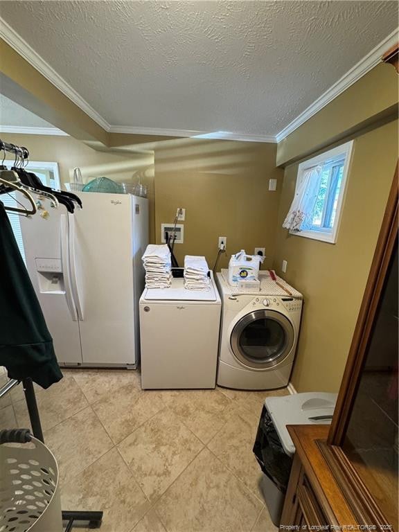 laundry area with light tile patterned floors, washer and dryer, crown molding, and a textured ceiling