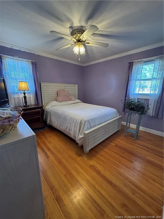 bedroom with ceiling fan, crown molding, and hardwood / wood-style flooring