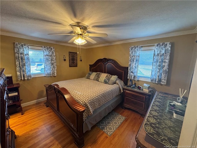 bedroom featuring ceiling fan, crown molding, a textured ceiling, and hardwood / wood-style floors