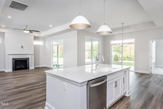 kitchen with white cabinetry, dishwasher, hanging light fixtures, a kitchen island with sink, and a tray ceiling