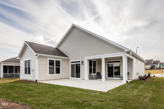 rear view of property with a lawn and a patio