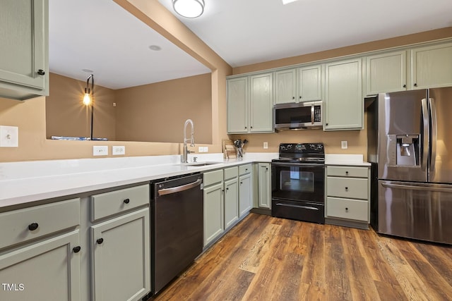 kitchen with sink, dark hardwood / wood-style floors, black appliances, and green cabinets