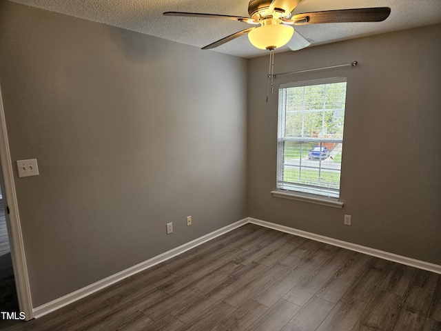 empty room with a textured ceiling, dark wood-type flooring, and ceiling fan