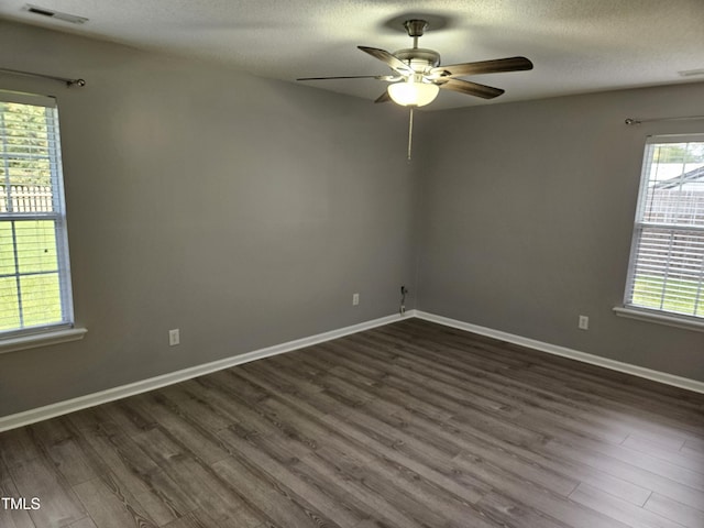 empty room featuring a textured ceiling, ceiling fan, and dark hardwood / wood-style flooring