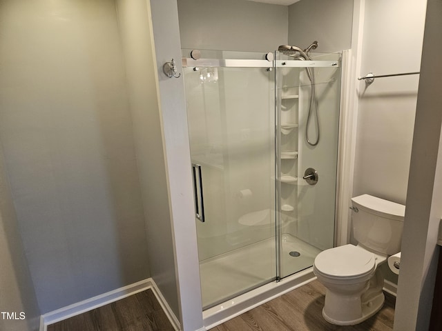 bathroom with hardwood / wood-style flooring, toilet, and walk in shower