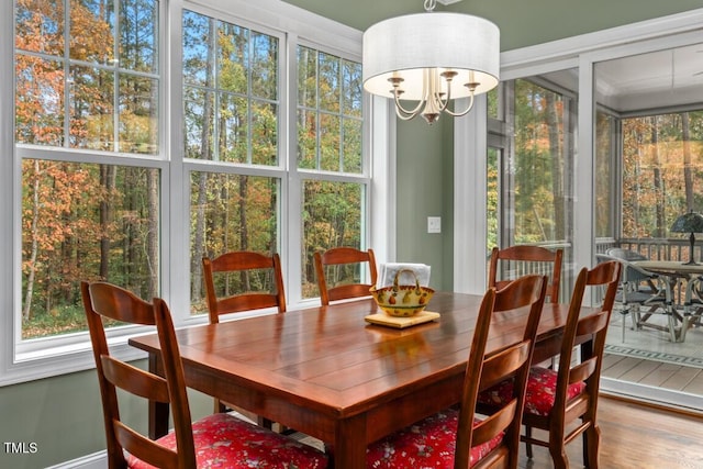 sunroom / solarium featuring an inviting chandelier