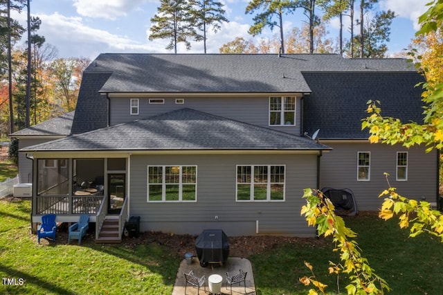 rear view of house with a sunroom and a yard