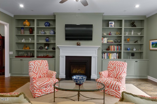 living area with crown molding, hardwood / wood-style floors, and ceiling fan