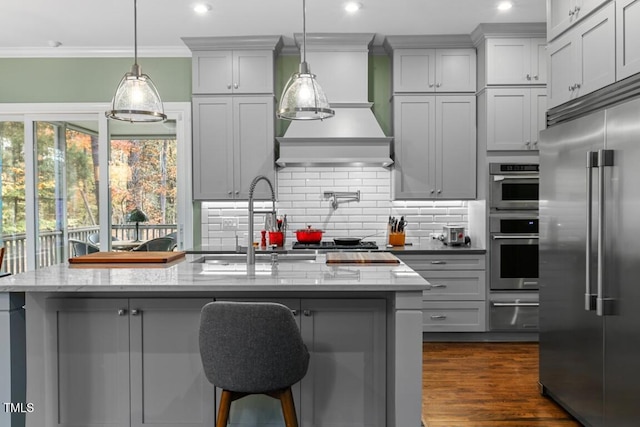 kitchen featuring stainless steel appliances, light stone countertops, gray cabinets, and decorative light fixtures