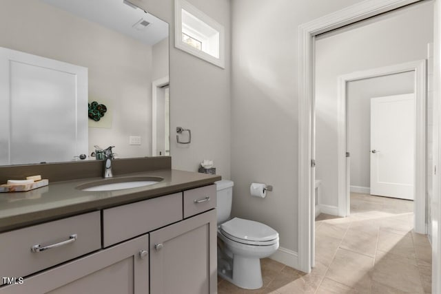 bathroom featuring vanity, toilet, and tile patterned flooring