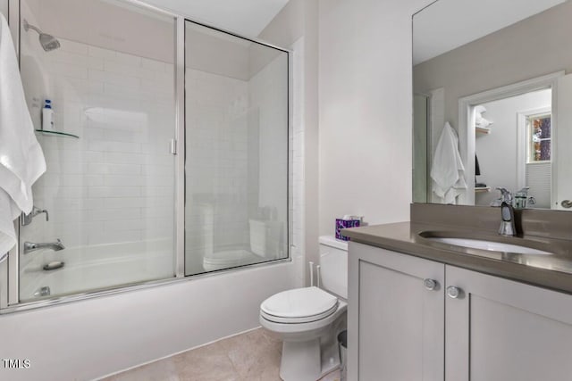 full bathroom with vanity, bath / shower combo with glass door, tile patterned floors, and toilet