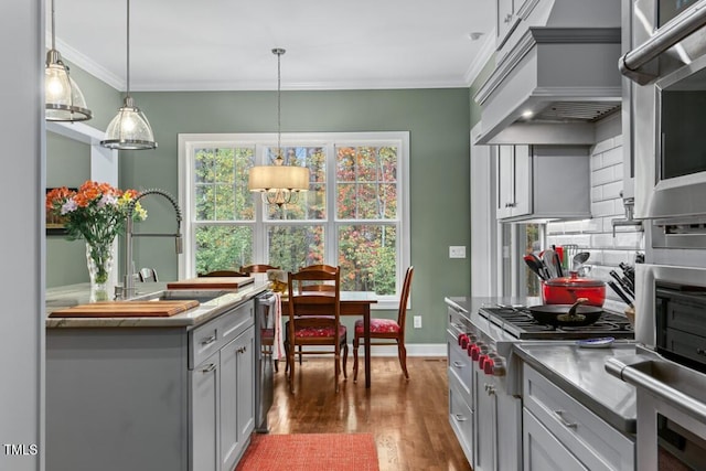 kitchen with crown molding, gray cabinets, hanging light fixtures, dark hardwood / wood-style floors, and custom range hood